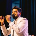 අමුතු විදිහම ආදරේ නම් ඒක එහෙමම තියේවා...! - "මැයි මාර ප්‍රසංගය" - "එයා කොහොම හරි මගේ කරගන්න ඕනි කියන එක දේශපාලනිකයි. එයා කොහේ හරි හොඳින් සතුටින් ඉන්න ඕන කියන එක විශ්වීයයි." ජීවන වීණාවෙන් වැයෙන බොහෝ ප්‍රේමණීය තාලයන් අතරේ හදවතක හරි පරිස්සමින් සුරකින, කවුරුත් නොදකින, මේක අමුතු විදිහේ ප්‍රේමයක්. කිසිදිනෙක හඬක් නොනැඟුණු අප්‍රකාශිත හැඟීම් දහස් ගණනක් මැද ඒකපාර්ශ්විකව එය දරා හිඳින්නට තරම් පරාර්ථකාමී වීම ලෙහෙසි පහසු දෙයක් නොවේ. එය ප්‍රේමයේ ගැඹුර කෙතරම් ද යන්න කියාපාන්නකි. එවන් ප්‍රේමයක් දරන හදවතක් උසුලන සියලු ප්‍රේම ආනිසංසයන් විටෙක ශාන්ත සුන්දරත්වයක් ඇති විඳීම් ය. නමුදු ඇතැම් විටෙක නිහඬ විඳවීම් ය. ඒ කරුණු කාරණා කෙසේ වුවත් ප්‍රේමය නම් ප්‍රේමයම වනු ඇත. කවදත් ලියන කලාවෙන් ආත්මයටම දැනෙන්නට ආමන්ත්‍රණය කරන මහින්ද ප්‍රසාද් මස්ඉඹුලයන්ගේ දෑතින් ලියැවුණු "මැයි මාර ප්‍රසංගය" නමැති නවකතාව ඇසුරින් නිර්මාණය වුණු "අමුතු විදිහම ආදරේ" නැතහොත් "මැයි මාර ප්‍රසංගය" නම් ගීතය, මහින්ද ප්‍රසාද් මස්ඉඹුලයන්ගේම අරුත්බර පද රචනාවට චතුර ගයාන් ජයනෙත්තිගේ අපූර්ව සංගීතය මුසු වී සුනීර සුමංගගේ ඉසියුම් හඬින් සහෘද හදවත් වෙත සමීප කර ඇති ප්‍රේමණීය ආමන්ත්‍රණයකි. "ඈත කන්දේ ගසක් සිටුවමි මල් පිපේවී කවද හෝ එහි එමල් ඔබහට පෙනී සිතට සතුටක් දැනේවා දැනේවා... දැනේවා..." ජීවන ගිරි දුර්ගය තරණය කරමින් යන අතරේ ජීවිතයට වසන්තය රැගෙන ආ නුඹ කෙරෙහි මගේ හදවත තුළ උපන් ප්‍රේමයේ නාමයෙන්, ඒ හැඟීම් සියල්ලක්ම පිවිතුරු ප්‍රාර්ථනාවක් ලෙසින් මේ වාතලයට මුදා හරිමි. කොහේ හෝ කවුරුත් නොදන්නා ඈතක මල් දරන ගසක් ලෙස එය පවතීවි. ඒ මම වග, මගේ ප්‍රේමය බව නුඹ කිසිදිනෙක දැන නොගනිවී. නමුත් ඒ පිපෙන මල් දැක, ඒ සුවඳින් නුඹේ හදවතට සතුට සැනසීම දැනේවා. කොහේ හෝ සතුටින් රැඳේවා! ඔබේ මුහුණේ සිනා සේයා මං නොදැක්කත් කමක් නෑ ඒක කන්දට පෙනේවා පෙනේවා.... පෙනේවා... ඒ කන්ද දෙස බලාගෙන මට ඉන්න ඉඩකඩ ලැබේවා... ලැබේවා.... ලැබේවා...... නුඹේ මුවෙහි ඇඳෙනා සිනා සේයා නුඹේ ළඟින් හිඳ දකින්නට මට නොහැකි වූවත් කමක් නැත. එහෙත් ඒ හැමදෙයක් දුරින් හිඳ හෝ මට විඳින්නට ලැබේවා! නුඹ තුටින් බව දැනෙන හැම විට මට සැනසීමක් දැනෙයි. මෙය ඒකපාර්ශ්වික ප්‍රේමයේ ගැඹුරු බව මනාව විදහා දක්වයි. වචන ස්වල්පයක් ඇතුළත විසල් අහසක් තරම් සිතුවිලි ගොන්නක් සඟවා තබා මෙම ගී පද හදවතේ සියුම් නිලයන් අල්ලා ගනියි. "මලෙක සුසුමත් සුසුමෙ ස්වරයත් ස්වරයෙ පැහැයත් වගේ අමුතු විදිහට සිතන්නට මම ඉගෙන ගත්තේ ඔබෙන් අමුතු විදිහම ආදරේ නම් ඒක එහෙමම තියේවා... තියේවා...තියේවා..." නුඹ නමින් මේ හදවතෙහි පිපෙන ප්‍රාර්ථනා මල්, සුසුම් ස්වරයන්, ඒ ස්වරයන් තුළින් මැවෙනා හදවතේ වර්ණ රටාවන් වල ඇති සුන්දරත්වය සේ අමුතු විදිහට හිතන්නට ඉගෙන ගත්තේ මා නුඹෙන් ය. එයත් හරියට පර නොවෙන පිවිතුරුම මැයි මාර මලක් වැනිය. පිපී සුවඳ දී හිනැහෙන නමුත් කිසිදිනෙක දෝතින් ගෙන අයිතියක් කීමට නොහැකි වූ ආදරණීයම හමුවීමක් ය. ඉතින්, මගේ එකම එක ප්‍රාර්ථනය නම් අයිතියක් කියන්නටත් නොහැකි, කවුරුත් නොදන්නා අමුතු විදිහේ ආදරේ එලෙස එහෙමම තියේවා...! මැයි මාර ප්‍රසංගයෙ හි එන සමිධ-සංචරණි ප්‍රේමය වගේම අමුතු විදිහේ ආදර කතා දහස් ගණනක් මේ අහස යට කෙතරම් නම් ඇති ද? ඒ වගේ හැඟීමකින් හිත පිරුණම කාලයත් එක්ක ඒ අමුතු විදිහේ ආදරේට බොහෝ අය ඇබ්බැහි වන්නේ නිරායාසයෙනි. ඉන් එහාට ඔවුන් ඒ ආදරේ එක්ක ජීවත් වෙන්න පටන් ගන්නා අතර සදාකාලෙටම හිත් ඇතුළේම ඒ ප්‍රේමයන් පරිස්සම් වී සැඟව යනවා. "මැයි මාර ප්‍රසංගය" ගීතය පුරාවට ම ඇත්තේ ඉතාමත් පිවිතුරු ප්‍රාර්ථනාවන් ය. ඒ ගීතය ම බලාපොරොත්තුවේ ආලෝකයක් ය. දැනටත් බොහෝ හදවත් තුළ සෙනෙහසින් දරා හිඳින සියල්ලක් අප්‍රකාශිත ඒකපාර්ශ්වික ප්‍රේමයන්ට සහ සියලු අහම්බකාරක හමුවීම් වලට මේ ගීතය තුළින් අරුතක් එක් කර ඇත. ඉතින්, මෙය ගැයෙන්නේ ඔවුනොවුන් කොහේ හෝ තැනක හොඳින්, සතුටින් ඇතැයි හිත සනසා ගත් සියලු විශ්වීය ප්‍රේමයන් වෙනුවෙනි. -නවෝද්‍යා ධනංජනී-