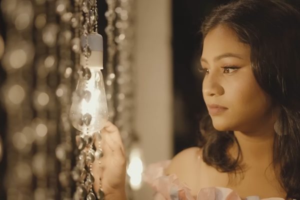 හිතින් අපි ආ දුර බොහෝමයි දරාගෙන අපි අපිවම…! – නුඹේ උණුසුම් හාදුවෙන් – හිතින් අපි ආ දුර බොහෝමයි දරාගෙන අපි අපිවම...! - නුඹේ උණුසුම් හාදුවෙන් - උන්මාදනීය ජීවානන්දයක ආස්වාදයත් බලාපොරොත්තුවේ ආලෝකයත් සදාකාලෙටම ඉතිරි කර ගිය මතකයත් යන සියල්ලම නුඹ නිසාය. මේ සියලු හැඟීම් වචන කරන්නේ හදවතේ ගැඹුරුතම ඉසව්වේ අගුළු හැර නවාතැන් ගත් නුඹ වෙනුවෙන්මය. කාලයත් සමඟ ජීවිතයට යන එන අය අතරේ සමහර හදවත් අපේ මුළු ජීවිත කාලෙටම සෑහෙන මතක ගොන්නක් හදවතේ ගැඹුරුම තැන් වල සනිටුහන් කර යයි. ජීවිතය තුළ අන් කිසිවකුත් ඔවුන්ට ආදේශ කළ නොහැකිය. ජීවිතේ කල් ඉකුත් වන්නට ප්රථම ඒ රැස් කර ගන්නා මතක බොහෝ වෙලාවට අයිති වන්නේ ආදරේ වැඩියෙන්ම දැනුණු තැන් වලටය. ඉතින්, දැනුණු තැන නතර වීම කෙසේ වෙතත් ඒ දැනුණු හිත් දරාගෙන බොහෝ දුර පැමිණ අතරමඟකින් හැරෙන්නට වුවහොත් එය ඉතාමත් ඛේදනීය තත්ත්වයක් වනු ඇත. නමුත් මේ ජීවිතය සදාකාලෙටම නොවන බැවින් සංසාර ගනුදෙනු වල අවසානය දක්වා මේ චක්රයෙහි අප ගමන් ගත යුතුව ඇත. කෙසේ හෝ ඒ හමුවීම් ජීවිතයට ආශිර්වාදයක් සහ වාසනාවක් සේ දැනෙනු ඇත. ජීවිත වලින් නික්ම යාම සහ විරහව වැළඳ ගත් මොහොතක වුව ඒ දෙස උපේක්ෂාවෙන් බලන්නට ඒ හමුවීම් සහ ඒ හදවත් හේතු කාරණා වනු ඇත. "නුඹේ උණුසුම් හාදුවෙන්" ගීතය ද මෙවන් වූ උපේක්ෂා සහගත ඉසව්වෙන් ප්රේමයේ ගැඹුරුතම ස්වරයන් තුළින් හදවත් වලට කතා කරන නිර්මාණයකි. මෙය ඉතාමත් සුමියුරුව සියුමිණී ඔපයංගිගේ හඬින් ගැයෙන අතර හර්ෂනී දිනුෂා අධිකාරීගේ ඉතාමත් අලංකාර සහ අර්ථවත් පද රචනාව සහ කපිල අපරැක්කගේ සංගීත දායකත්වයෙන් නිර්මාණය වූවකි. "නුඹේ උණුසුම් හාදුවෙන් මගේ හිත පිරීමදින්න ආදරේ තව සියුම් තැන් ඇති ලංවෙලා මට කියන්න..." ප්රේමයේ ගැඹුර කොයි තරම් ද යන වග හදවත් වලට දැනෙනුයේ අන් කවරදාටත් වඩා අනෙකාව දැනෙන ඔවුන් සමඟ ගෙවෙන එක් කුඩා මොහොතක් වුව මඟ හැර ගන්නට ලොබ බඳින, වචනයෙන් කියා ගත නොහැකි හැඟීම් පමණක් ම වන තැන් වලදීය. නුඹේ උණුසුම් හාදුවෙන් පිරිමැදෙන්නේ මා ගත නොවේ හිතය. ඒ මට නුඹව උපරිමව දැනෙන තැනය. ආදරේ තව අප නොවිඳි සියුම් මොහොතවල් පවා නුඹ සමඟ විඳින්නට හැකි නම් මා හට ඇති එකම සැනසුම එයයි. "යන්තමට හරි නුඹට හිතුනොත් මගේ හිත මගහරින්න මතක පැන් ටිකක් අරගෙන නුඹේ හිතටම ඉහින්න..." අපි දෙදෙනා ඇවිද ආ මාවතෙහි කොතැනක හෝ අතරමඟින් හැරෙන්නට කෙදිනක හෝ නුඹට සිතුණොත් අපේ මතක වලින් මතක පැන් ටිකක් ගෙන නුඹේ හිතට ඉසින්න. ඒ පද පෙළ ඉතාමත් රූපකාර්ථයෙන් අර්ථවත් ලෙස හැඩ ගන්වා තිබීම අපූර්වය. එහි සරල අර්ථය නම් නුඹට මාව මඟ හරින්නට සිතුණොත් අප දෙදෙනා එක්ව ගත කළ ඒ සොඳුරු දවස්, ඒ සුන්දර මතක කෙතරම් නම් ඉමිහිරිද යන්න වග යළි යළිත් ආවර්ජනය කර බලනු මැන යන්නයි. "හිතින් අපි ආ දුර බොහෝමයි දරාගෙන අපි අපිවම හිතේ ගැඹුරුම තැනක ලිව්වා මගේ ප්රේමය නුඹටම..." නුඹව හමු වී ගත වූ කාලය කෙතරම් කෙටි ද දිගු ද යන්න කෙසේ වෙතත් හිතින් අපි අපිව දරාගෙන අපි අපිව බෙදා ගනිමින් සනසවමින් පැමිණි දුර බොහෝමය. එය සංසාරයක් තරම් දිගු බවක් උසුලන බව දැනෙයි. ඉතින්, කිසිවෙකුටත් ඇතුළු වීමේ ප්රවේශ නොදුන් මගේ හදවතේ ගැඹුරුතම තැනක හරි පරිස්සමට මම නුඹේ නමට මගේ ප්රේමය සදාකාලෙටම ලියා තැබුවෙමි. "කඩන් වැටෙනා පුංචි තරුවක් දෙස බලන් මම හිතන්නම් සසර ගනුදෙනු ඉවර වෙනකන් නුඹව විතරක් පතන්නම්..." නුඹත් මමත් හිඳින මේ විසල් අහස දෙස බලන හැම මොහොතකම කඩන් වැටෙනා පුංචි තරුවක මම මගේ ප්රාර්ථනාවන් නුඹ නමින් තබන්නෙමි. ඒ හැම මොහොතකම නුඹේ සතුටම ප්රාර්ථනා කරන්නෙමි. සංසාර චක්රයෙහි ගනුදෙනු සියල්ලම අවසාන වන තෙක් නුඹව පමණක් පතන්නෙමි. මේ පිවිතුරුම හැඟීම් නුඹ නමින් පමණක් ම වනු ඇති. "හිතේ කකියන හුඟක් දේවල් ඇස් පියන් මට කියන්න නුඹයි හිටියේ මගේ තනියට මගේ කියලා දැනෙන්න..." මගේ හදවතේ පැන නඟින සියලු සිතුවිලි නොසඟවා නොරවටා කිව හැකි කෙනෙක් සිටියා නම් ඒ නුඹය. හිතේ සිර කරගෙන සිටි බොහෝ දෑ සහ අදටත් කිසිවෙකු සමඟ නොකී ඇතැම් දේ ගැන නිදහසේ නිවී සැනසිල්ලේ ඇස් පියන් වුව තොරක් නොමැතිව කියන්නට මට සිටියේ නුඹ පමණමය. සිතට එන හැමදේම බෙදා හදා ගන්නට හැම හුදෙකලා මොහොතකම මගේ යැයි මං හදවතින් බදා ගත් කෙනෙක් වේ නම් මගේ තනියට සිටි ඒ නුඹමය. නමුත් මා නොදන්නා කාරණාව නම් නුඹට එය කෙසේ දැයි යන්න වග පමණි. "නුඹයි ආවේ මා සොයාගෙන ආදරේ කවි ලියන්න මගේ හිත ළඟ නතර උනෙ ඇයි කවදහරි මට කියන්න..." දයාලූ හස්තයෙන් මගේ හිත පිරිමැද ආදරේ කවි මල් ද රැගෙන මා සොයා මගේ ජීවිතයට කොහේදෝ සිට පැමිණියේ නුඹය. නොසිතූ මොහොතක නොසිතූ අයුරින් ආදරේට අරුත් රැගෙන මගේ ජීවිතය සැරසුවේ නුඹය. එදා පටන් ආදරේ කවි ලියූවේ නුඹ නමින් ය. නමුදු මට නුඹෙන් අසන්නට ඇත්තේ මෙය පමණමයි. ජීවිතේ කෙදිනක හෝ නුඹට සිතුණොත් මට මෙය කියන්න. "මගේ හිත ළඟ නතර උනෙ ඇයි කවදහරි මට කියන්න" එහෙම දවසක් එනතුරුම මම මඟබලාගෙන හිඳින්නෙමි. ආදරය යනු අයිති කර ගැනීමට වඩා ගැඹුරක් දරන පිවිතුරුම හැඟීමක් බවට මේ ගීතය සාක්ෂි දරයි. මෙයට සවන් දෙන සෑම මොහොතකම භාවනාවක් සේ සමවැදෙන අයුරින් සහෘද හදවත් ඇද බැඳ තබා ගන්නා අතර මෙම නිර්මාණය ආදරේ ගැඹුර මනා ලෙස හදවත තුළ රඳවයි. සමාජය තුළ ගී රසාස්වාදය වැඩි දියුණු වීම සඳහා මෙවන් වූ සෞම්ය ගණයේ ගීත නිර්මාණය වීම බෙහෙවින් ඇවැසිමය. ඉතින්, මේ සක්වළල්ල තුළ ප්රේමය නමින් පණ ගැහෙන ජීවිත මතක වලට සහ පිවිතුරු ආදරයන්ට මෙම ගීතය තුළින් ගැඹුරු සෞන්දර්යයක් එක් කරනු ඇත. -නවෝද්යා ධනංජනී-